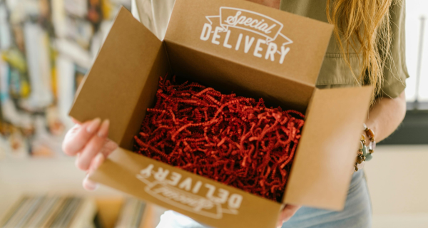 Woman holding box packed with red paper interior